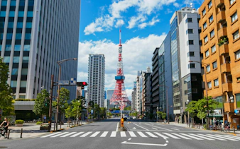 Tokyo Tower framed by city buildings on a clear day.