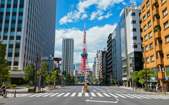 Tokyo Tower framed by city buildings on a clear day.