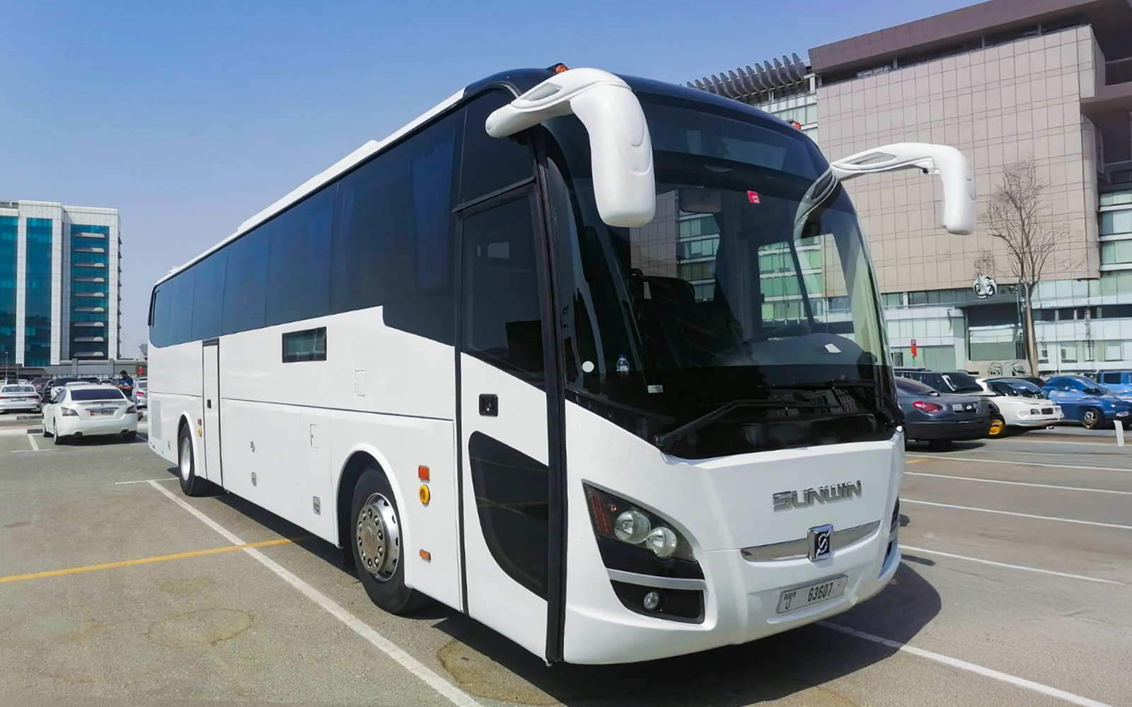 Tour bus for Dubai Safari Park transfers in a parking lot.