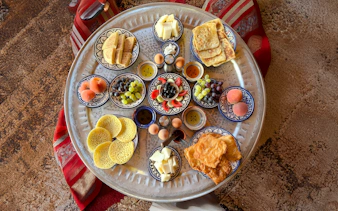 Traditional Berber breakfast spread with fruits and pastries in caidal tent, Marrakech.