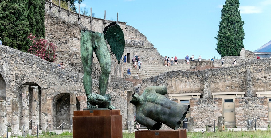 Ancient ruins and bronze statues at Pompeii archaeological site, Italy.