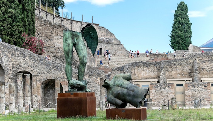 Ancient ruins and bronze statues at Pompeii archaeological site, Italy.