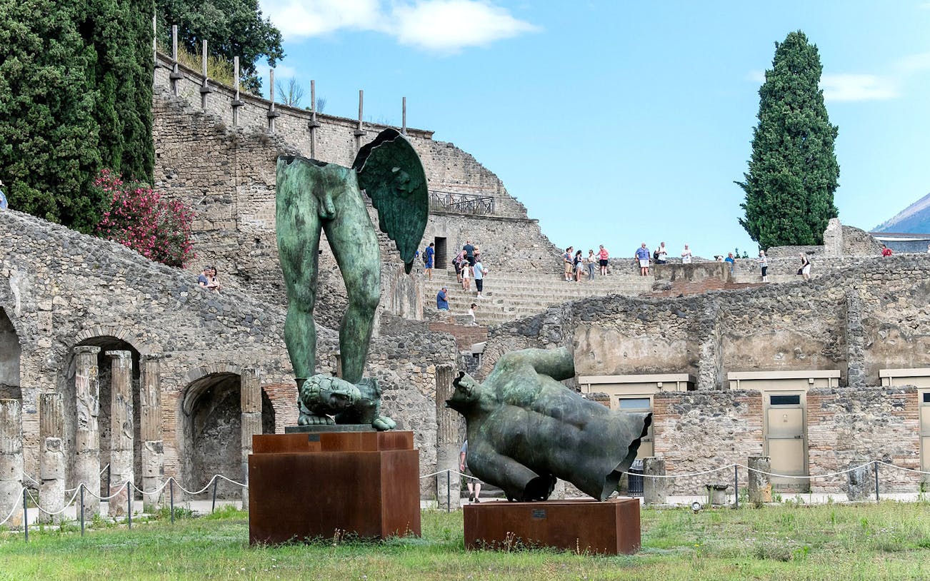 Ancient ruins and bronze statues at Pompeii archaeological site, Italy.