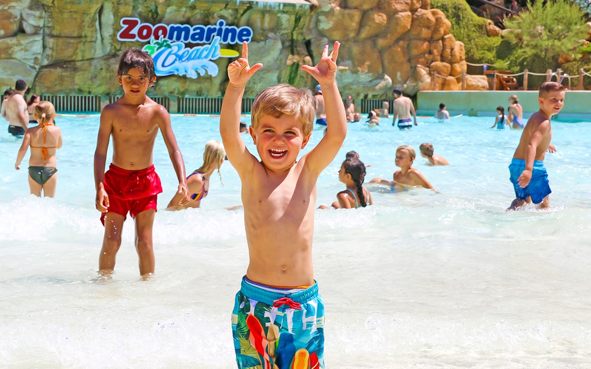 Children playing in the water at Zoomarine Portugal beach area.