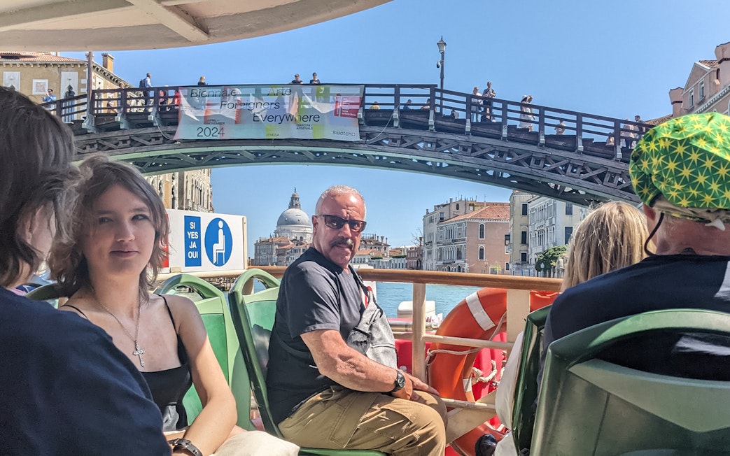 Passengers on Venice ACTV water bus with view of Ponte dell'Accademia and Santa Maria della Salute.