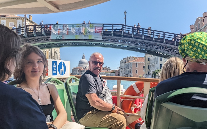 Passengers on Venice ACTV water bus with view of Ponte dell'Accademia and Santa Maria della Salute.