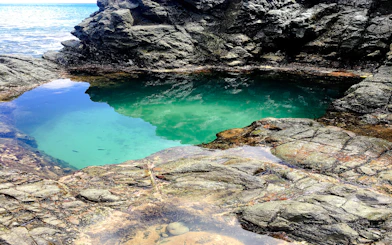 Natural pool with clear water surrounded by rocks at Buraco do Galego, Noronha.