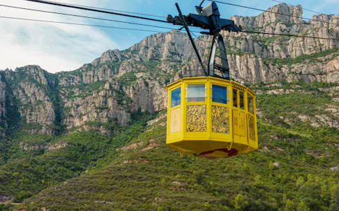 Yellow cable car ascending Montserrat mountain, Spain.