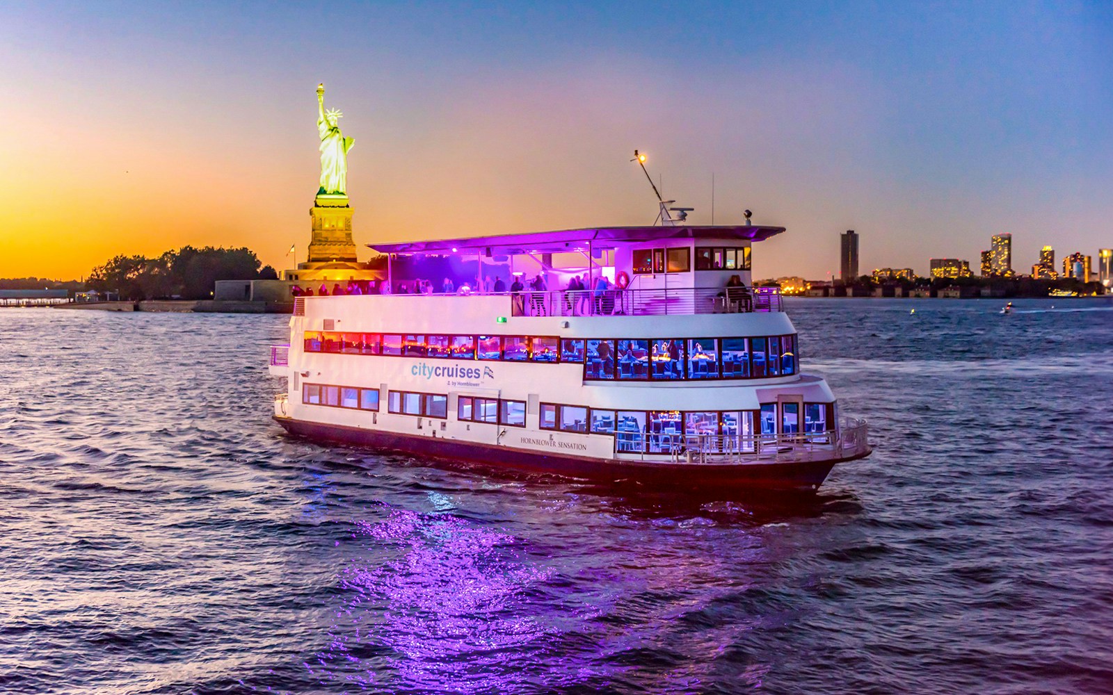 People enjoying a sunset party cruise on the New York City skyline.