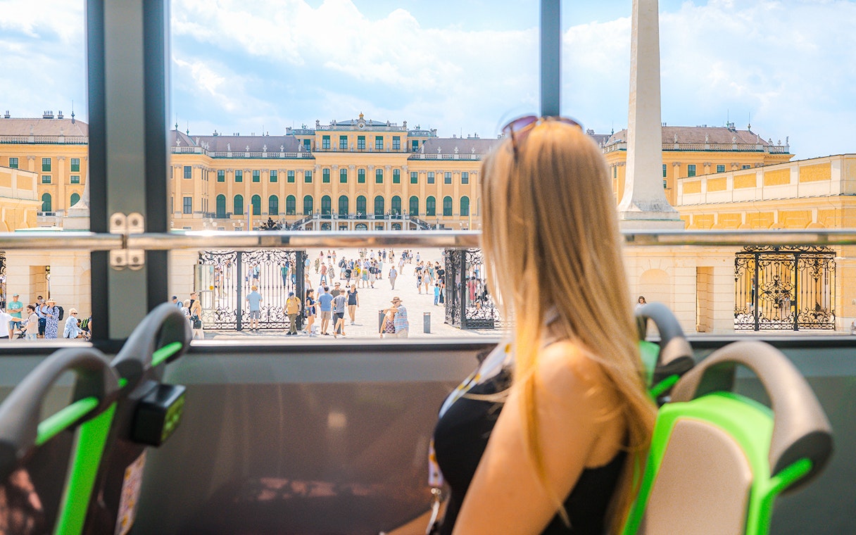 Tourist views Schönbrunn Palace from Vienna sightseeing bus.