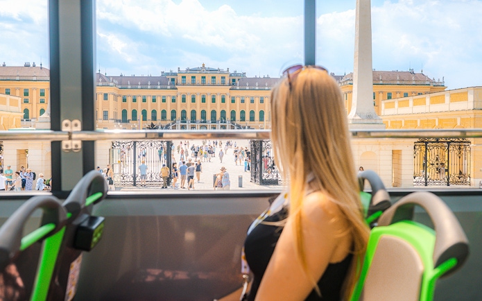 Tourist views Schönbrunn Palace from Vienna sightseeing bus.