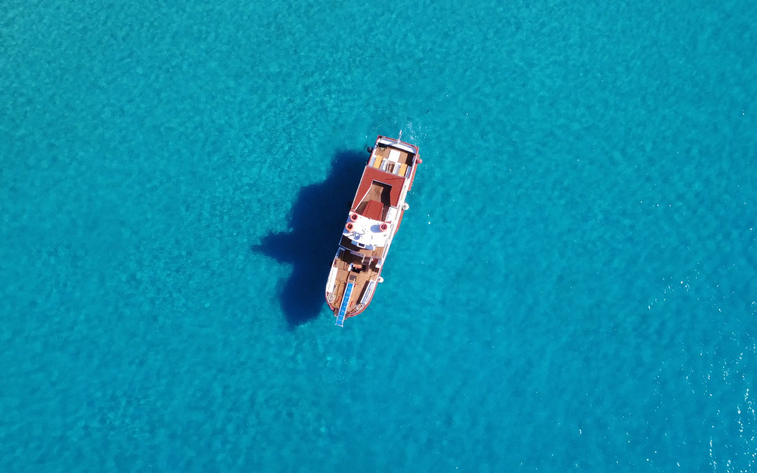 Boat cruising in clear turquoise water, Beach Hopper Cruise, Ibiza.