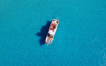 Boat cruising in clear turquoise water, Beach Hopper Cruise, Ibiza.