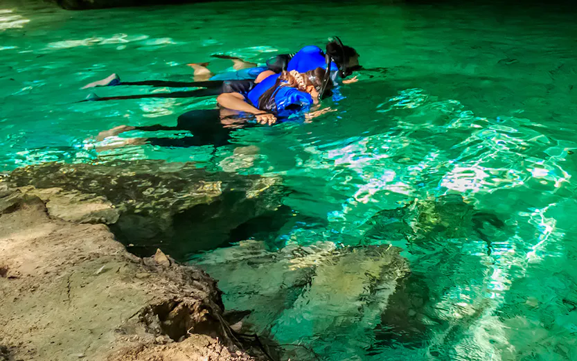 Snorkelers exploring a cenote in Cancun, Mexico.