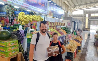 Tourists at a fruit market during a private Hurghada city tour with hotel pickup.