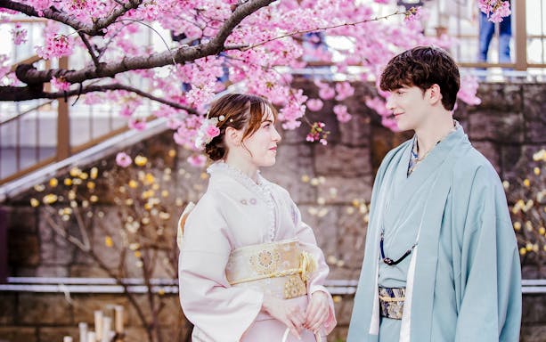 Couple in kimonos under cherry blossoms in Japan.