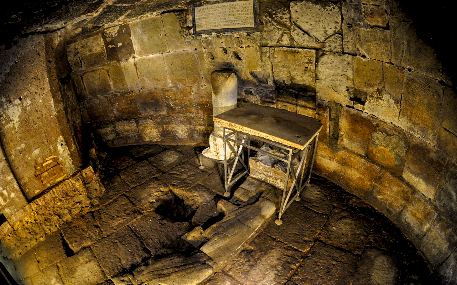 Mamertine Prison interior with ancient stone walls and table in Rome.