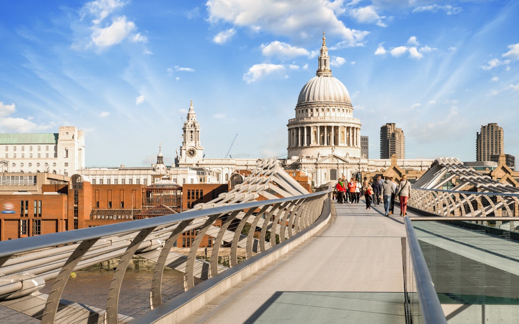 Millennium Bridge over River Thames with St. Paul's Cathedral in London.