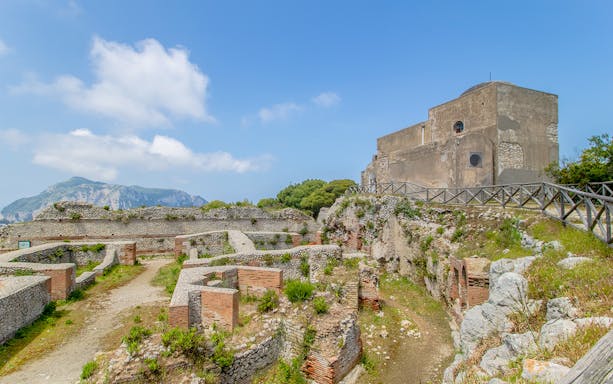 Ruins of Villa Jovis on Capri Island with stone walls and ancient structures.