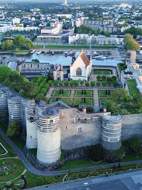 Aerial view of Angers Castle with gardens and surrounding cityscape in Angers, France.