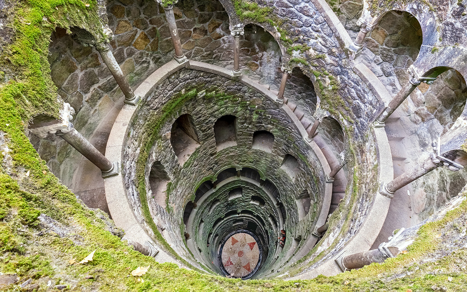 Tour guide leading a group through the lush gardens of Quinta da Regaleira in Sintra, Portugal