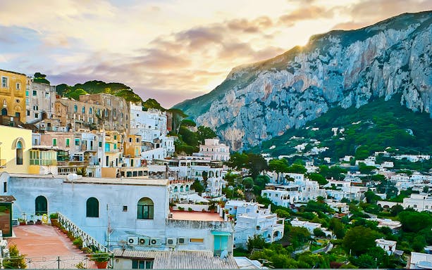 Sorrento coastal townscape with colorful buildings and cliffs at sunset.