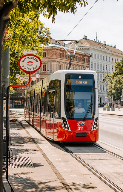 Tram on Vienna street near historic buildings, part of Vienna City Card benefits.