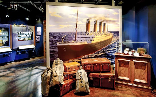 Titanic Museum exhibit with ship mural, luggage, and third-class artifacts in Pigeon Forge.