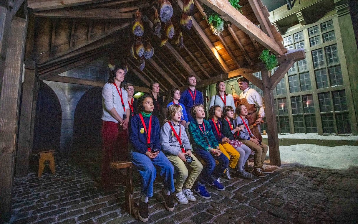 Guests watching a presentation at Historium Bruges under a wooden roof.