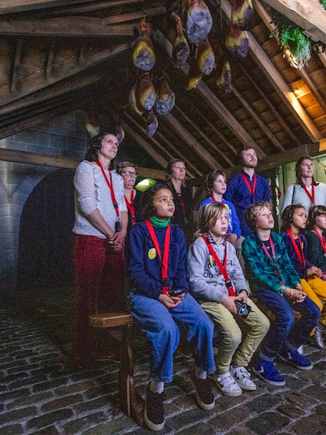 Guests watching a presentation at Historium Bruges under a wooden roof.