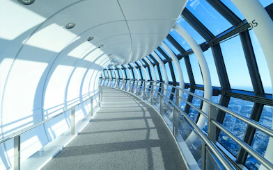 Curved glass corridor at SkyTree Observation Deck, Tokyo, with city view.