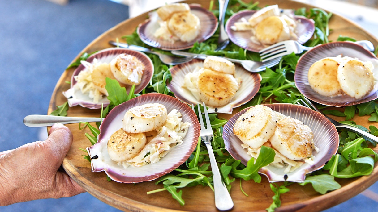 Group of tourists enjoying a luxurious seafood cruise around Rottnest Island, with clear blue waters and scenic views