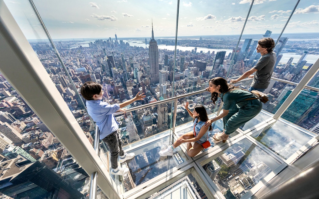 Visitors enjoying the view from the glass floor at SUMMIT One Vanderbilt, New York City.