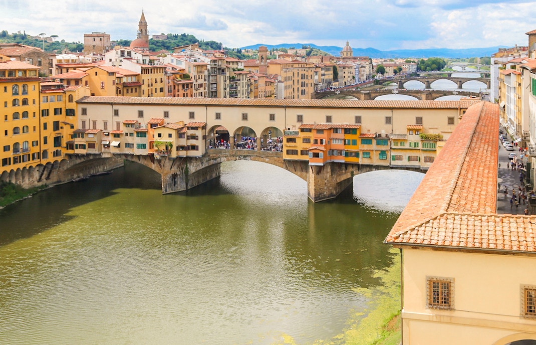 Ponte Vecchio and Vasari Corridor spanning the Arno River in Florence, Italy.