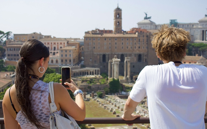 Couple viewing Roman Forum during guided tour in Rome.