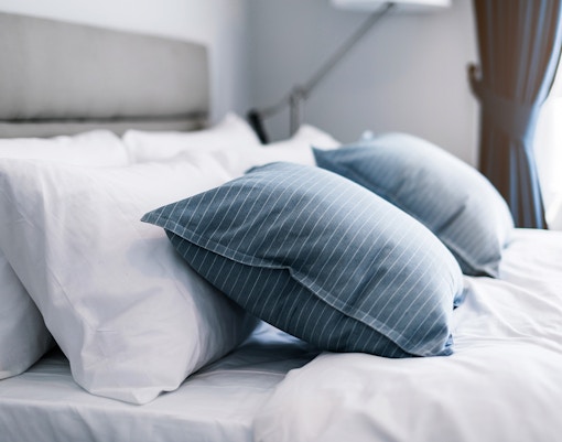 Hotel room with neatly arranged bed.