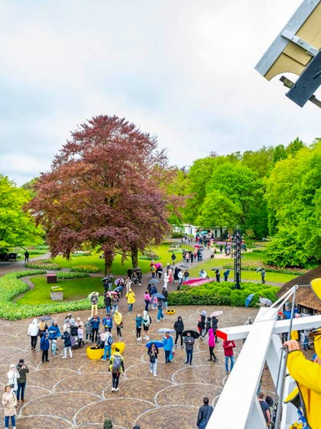 Visitors enjoying the view from Keukenhof windmill, surrounded by gardens and pathways.