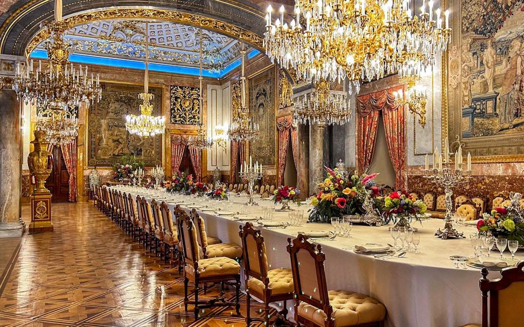 Dining room with chandeliers and ornate decor inside Royal Palace of Madrid.