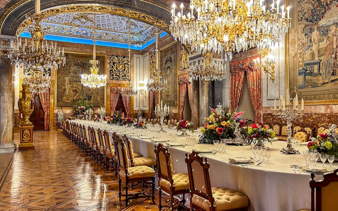 Dining room with chandeliers and ornate decor inside Royal Palace of Madrid.