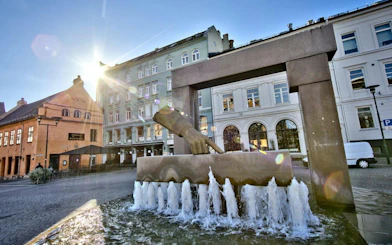 Fountain with pointing hand sculpture in central Oslo during walking tour.
