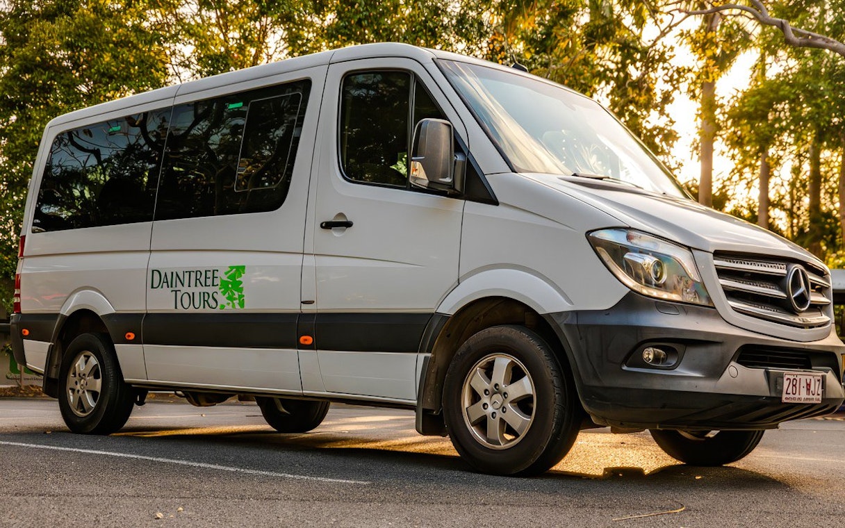 Daintree Tours coach parked on a sunny road, ready for transfer.