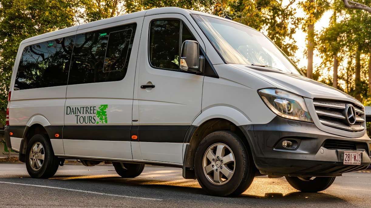 Daintree Tours coach parked on a sunny road, ready for transfer.