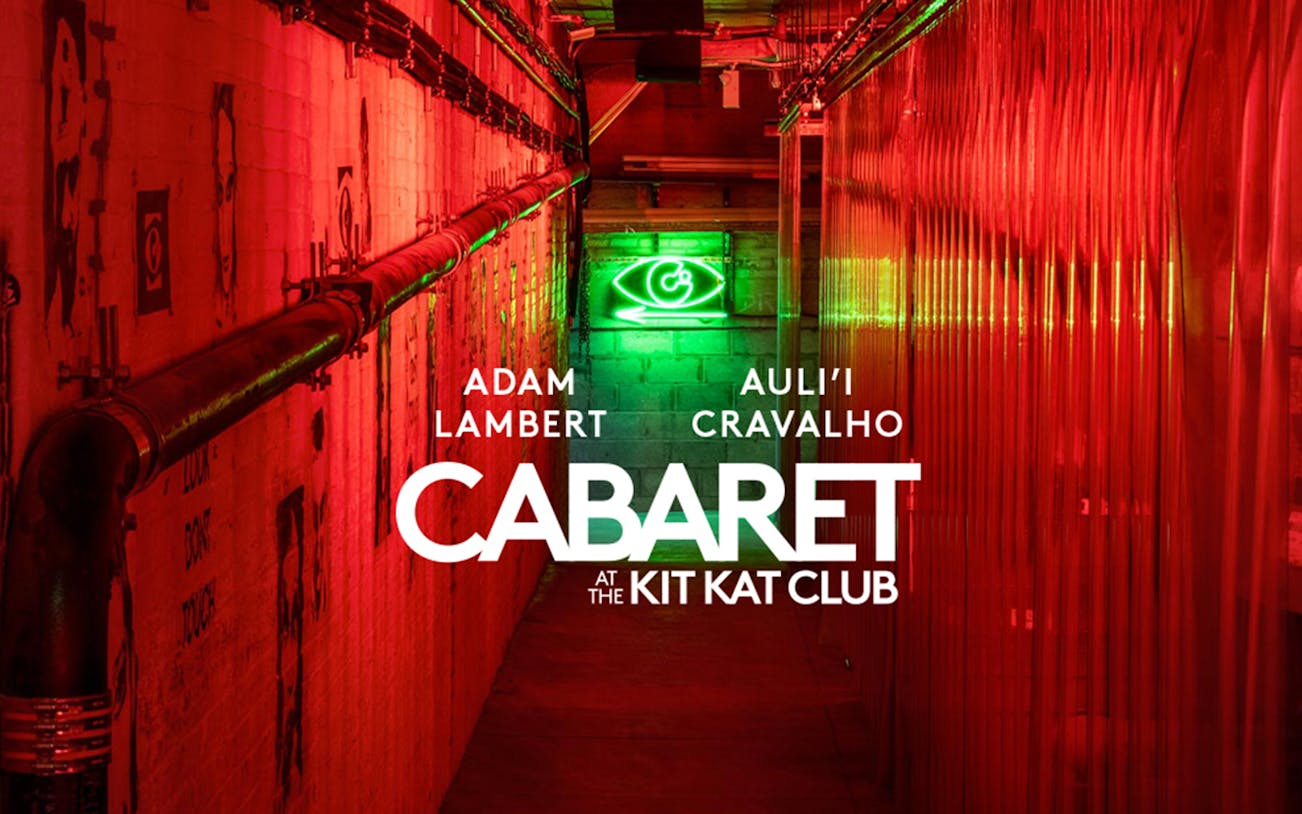 Cabaret show at Kit Kat Club with neon lights and red hallway.