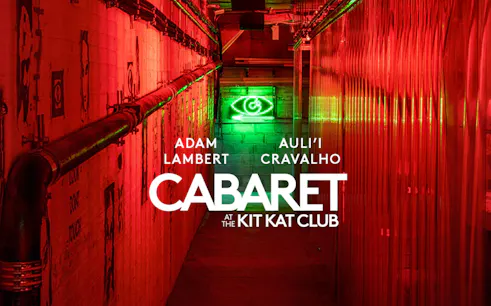 Cabaret show at Kit Kat Club with neon lights and red hallway.