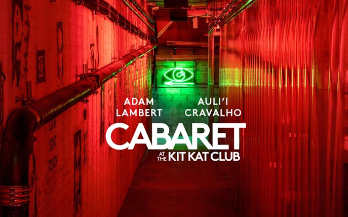 Cabaret show at Kit Kat Club with neon lights and red hallway.