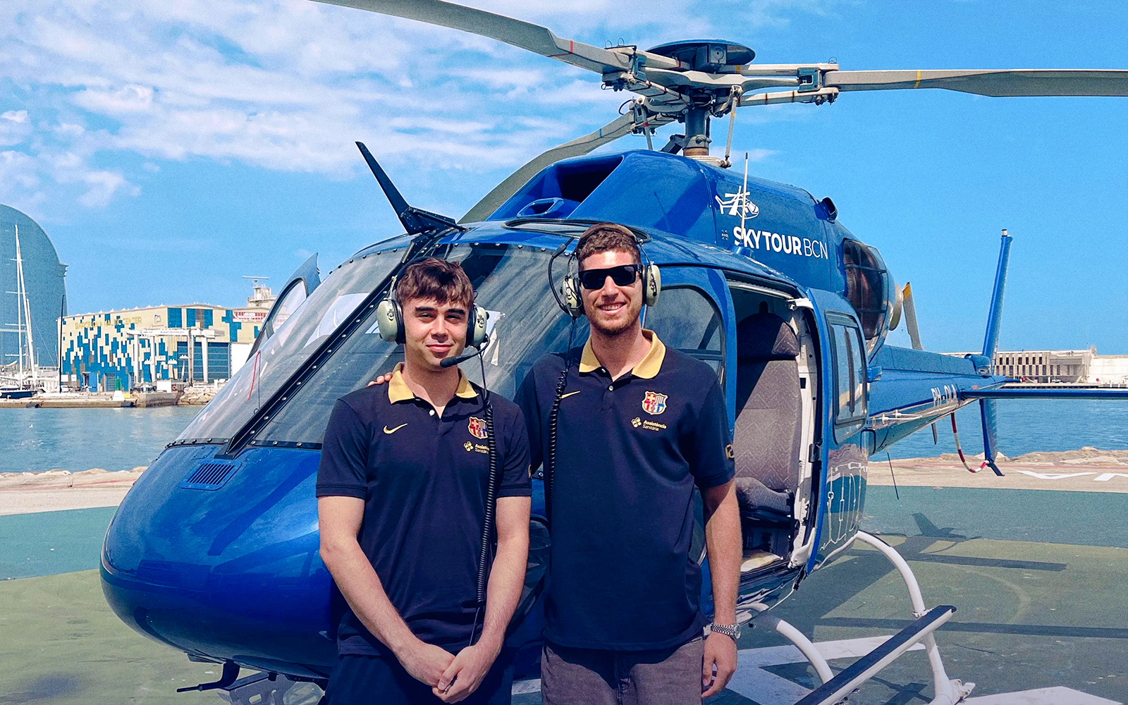 Helicopter on Barcelona helipad with two pilots ready for Barca Sky Tour.
