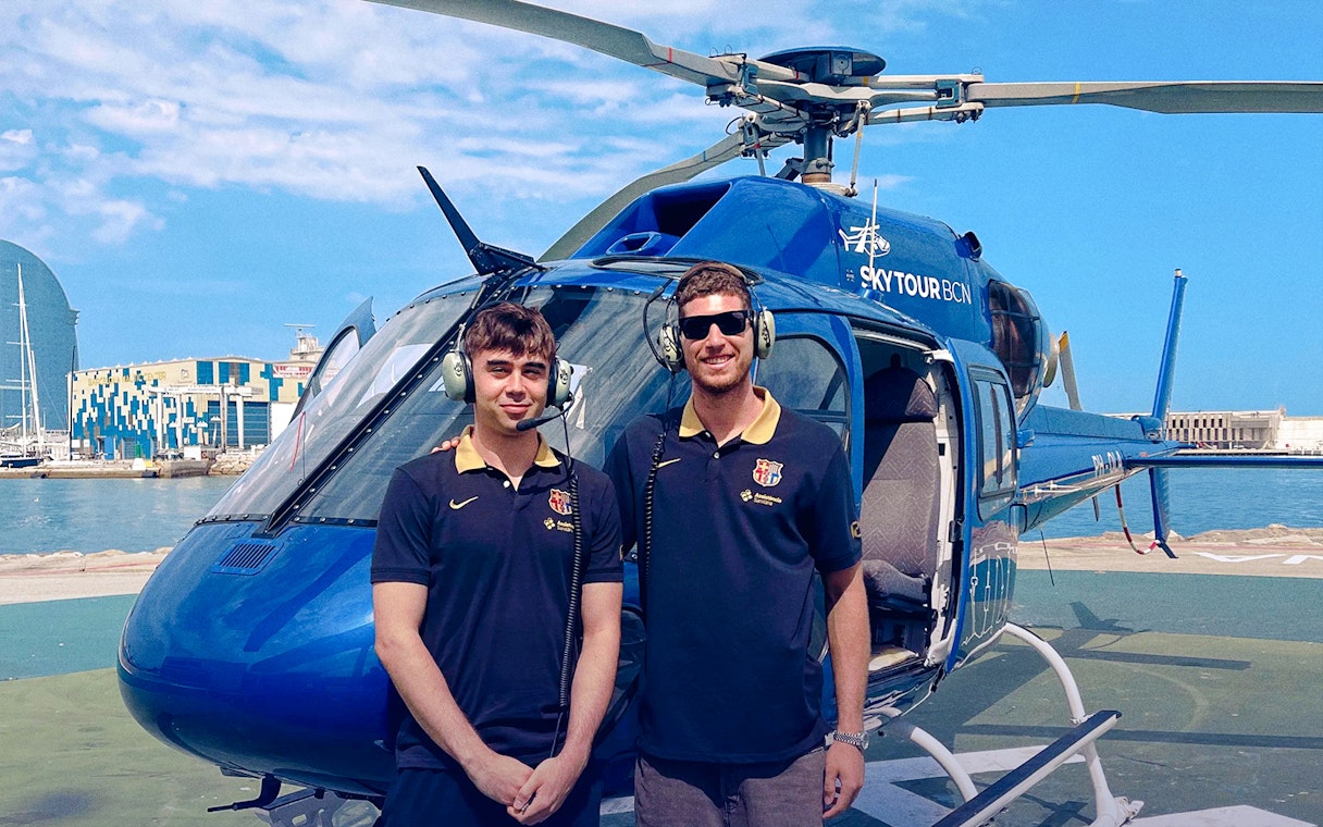 Helicopter on Barcelona helipad with two pilots ready for Barca Sky Tour.