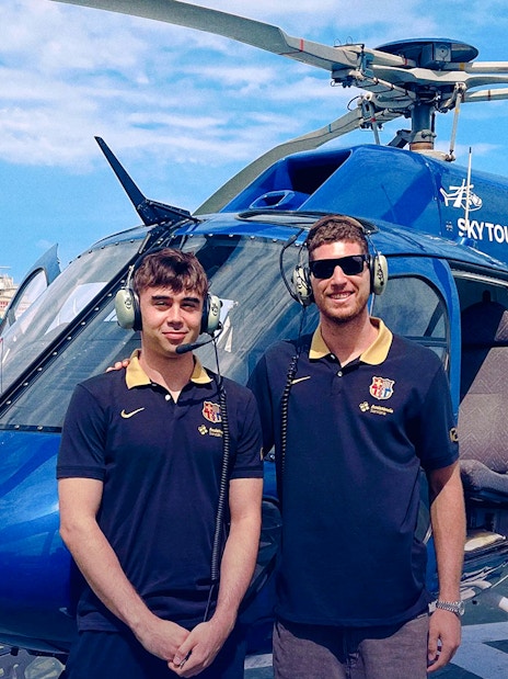 Helicopter on Barcelona helipad with two pilots ready for Barca Sky Tour.