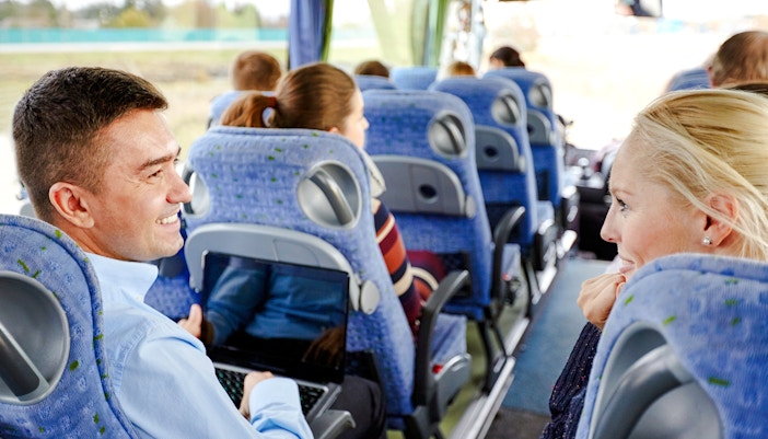 Group of happy passengers in a travel bus on a Las Vegas Grand Canyon tour.