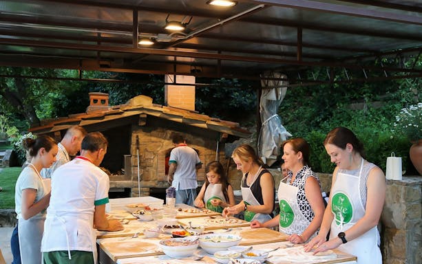 Cooking class participants making pizza at a Tuscany farmhouse near Florence.